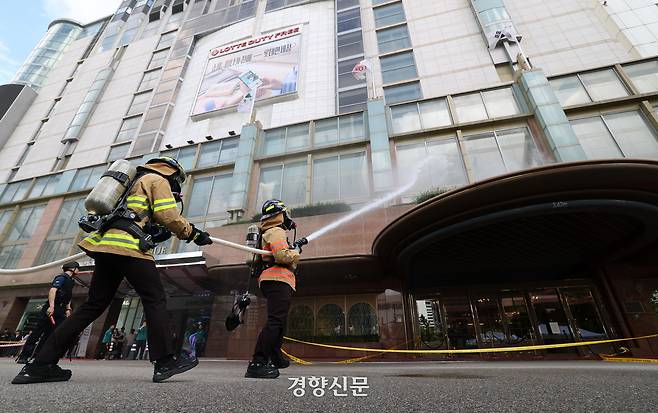 19일 서울 중구 롯데호텔에서 열린 을지연습 연계 통합방위능력 향상 관계기관 합동훈련에서 소방관들이 드론 테러 공격으로 인해 호텔에 화재가 발생한 상황을 가정해 화재진압 훈련을 하고 있다.