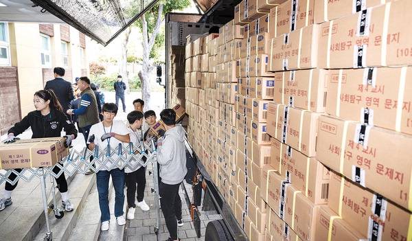 부산 동래구 한 학교에서 관계자들이 2025학년도 대학수학능력시험(수능) 문제지를 차에서 내리고 있다.  국제신문DB