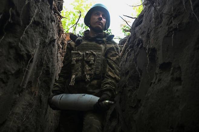 13일 러시아의 우크라이나 공격 속에서 우크라이나군 제141 독립 기계화 여단의 군인이 도네츠크 지역 전선에서 러시아 군대를 향해 발사하기 전에 포탄을 운반하고 있다. 2025.5.13  /로이터=뉴스1