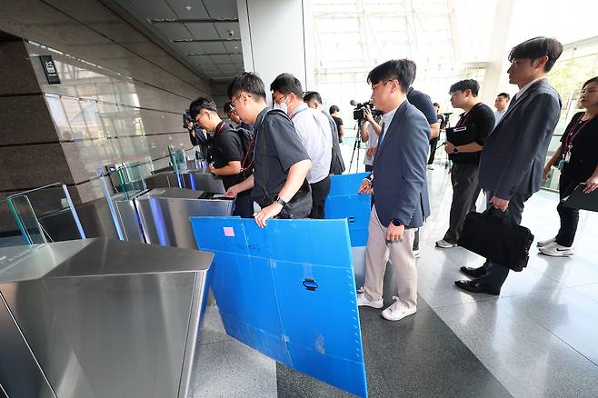 경기남부경찰청과 고용노동부 관계자들이 경기도 광명시 포스코이앤씨 고속도로 건설공사 현장의 미얀마인 근로자 감전 사고와 관련해 12일 포스코이앤씨 인천 본사(인천 연수구) 압수수색을 위해 사옥으로 들어가고 있다.  [연합]