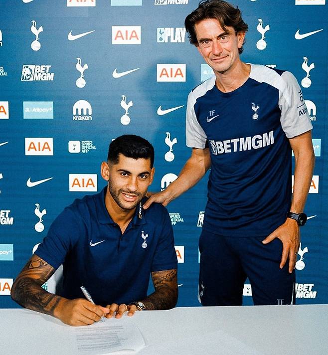 토트넘 크리스티안 로메로(왼쪽)가 토마스 프랑크 감독이 지켜보는 가운데 구단과 4년 재계약에 사인하고 있다. 토트넘 SNS