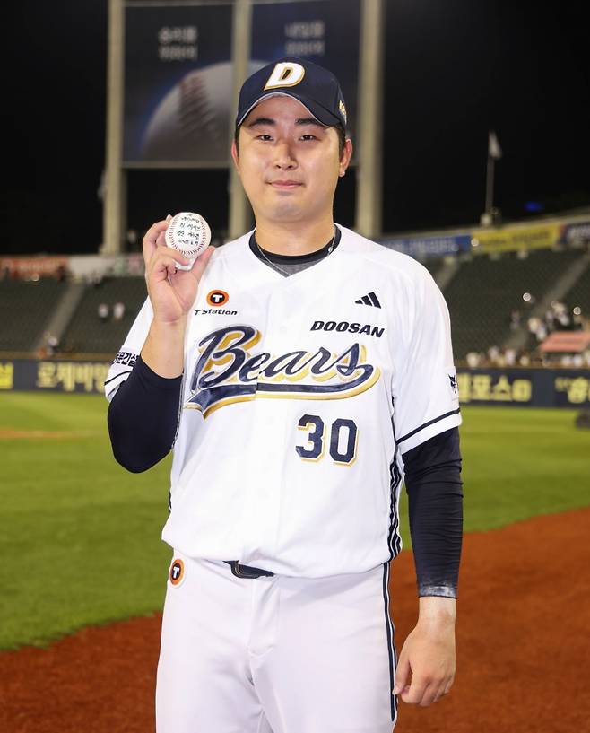 두산 베어스 김정우가 17일 잠실 KIA전에서 데뷔 첫 세이브를 챙긴 뒤 기념구를 들며 포즈를 취하고 있다. /사진=두산 베어스 제공