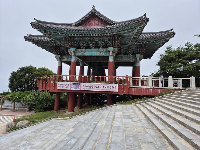 경주 토함산에 위치한 석굴암통일대종의 종각(鐘閣)이다. 전통 양식의 화려한 팔작지붕과 단청 아래 ‘불우이웃돕기 소원성취 3타 종치기’ 현수막이 걸려 있어, 신라문화의 계승과 현대적 기원의 공간으로 활용되고 있음을 보여준다.