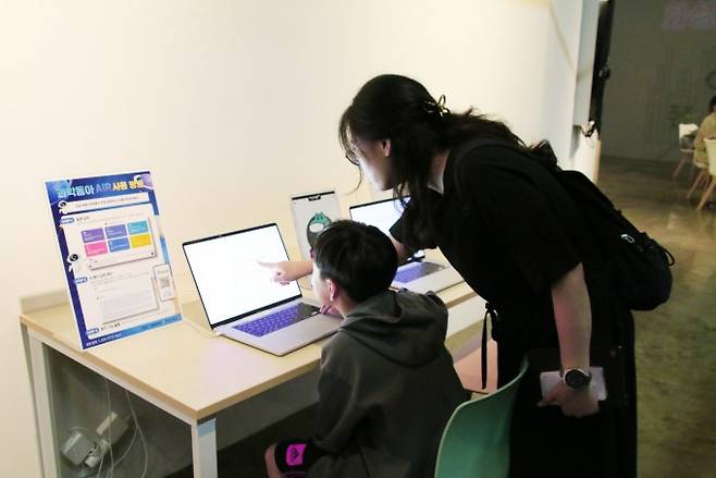 박다온 하길초 4학년 학생이 어머니 정수현 씨와 함께 화성ICT생활문화센터 메이커스페이스에서 과학동아AiR에 평소 궁금했던 질문을 하고 있다. 동아사이언스 제공