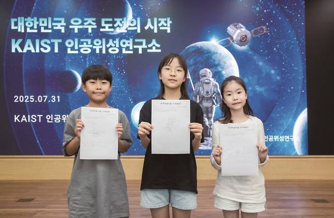 어린이 기자들이 우주물체 능동제어 위성 그림을 들고 있다. 스튜디오 51 제공