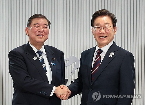 이재명 대통령이 지난 6월 17일(현지시간) 캐나다 앨버타주 캐내내스키스 주요 7개국(G7) 정상회의장에서 열린 한일 정상회담에서 이시바 시게루 일본 총리와 악수하며 기념촬영을 하고 있다.  [캐내내스키스(캐나다)=연합뉴스]