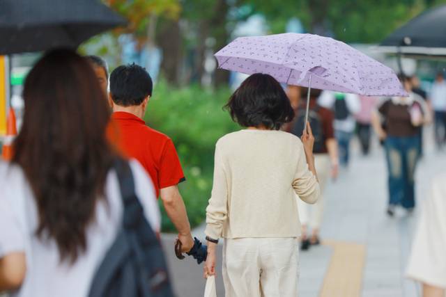▲ 소나기가 내린 서울 세종대로에서 우산을 쓴 시민과 우산을 손에 든 시민이 이동하고 있다. 연합뉴스