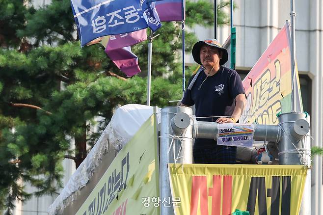 정리해고 철회 등을 촉구하며 고공농성을 하는 고진수 민주노총 세종호텔 지부장이 지난 7월25일 서울 중구 세종호텔 앞 고공농성장에서 김영훈 고용노동부 장관과 전화 통화를 하기 위해 기다리고 있다. 성동훈 기자