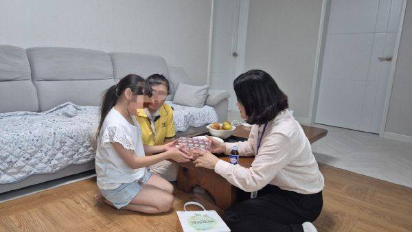 성주군 관계자가 18일 성주시장 양말가게 사장으로부터 기부받은 타이츠를 가정에 전달하고 있다. 성주군 제공