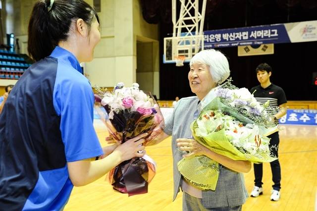 2015년 박신자컵에 참석한 박신자 여사가 당시 고교생 국가대표로 활약 중이던 박지수(청주 KB스타즈)에게 꽃다발을 받고 있다. 사진=WKBL 제공