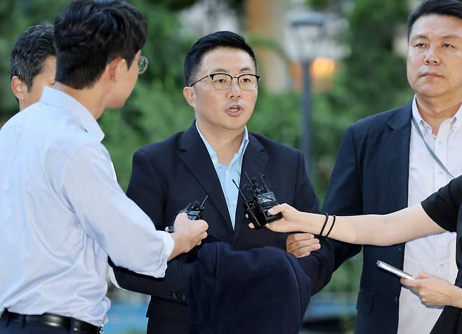 김건희 여사 일가의 ‘집사’로 지목된 김예성 씨가 12일 귀국 직후 인천국제공항에서 체포돼 서울 종로구 김건희특검 사무실에 인치되며 취재진의 질문을 받고 있다. [연합]