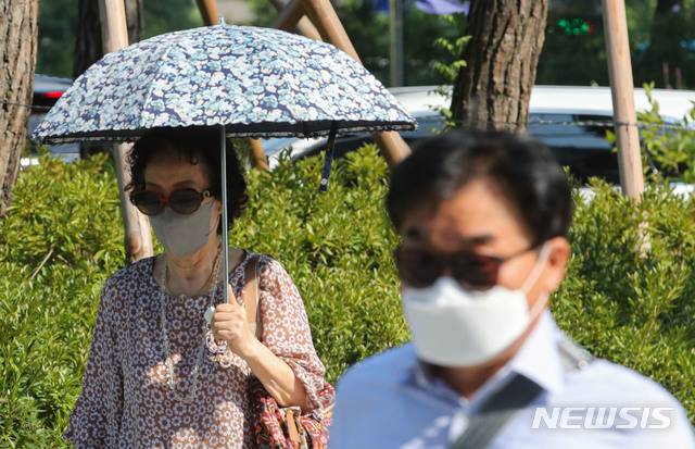 [서울=뉴시스] 권창회 기자 = 서울 종로구 광화문역 인근에서 시민들이 양산과 선글라스를 쓰고 이동하고 있다. (사진은 기사 내용과 관련이 없습니다.) kch0523@newsis.com