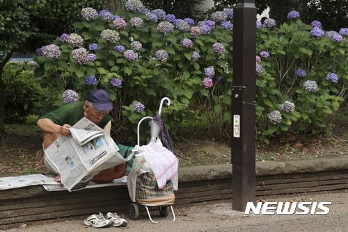 [도쿄=AP/뉴시스]일본 도쿄 우에노 공원에서 5일 한 노인이 신문을 읽고 있다. 2017.07.05