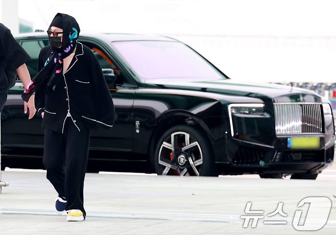 빅뱅 지드래곤(GD)이 해외 일정을 위해 20일 오후 인천국제공항에 도착해 최고급 SUV 차량에서 내린 뒤 출국장으로 이동하고 있다. 이날 지드래곤은 샤넬 로고가 있는 머플러를 머리에 두르고 나타나 눈길을 끌었다. ⓒ News1 권현진 기자