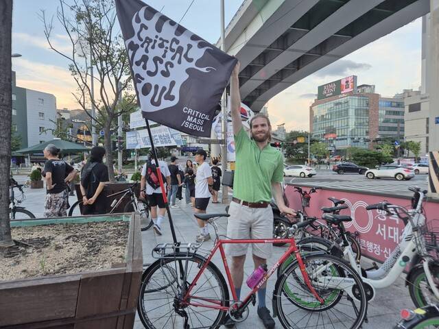 크리티컬매스서울 참가자 쥘 미쇼가 16일 서울 서대문구 독립문 앞에서 자전거에 단 깃발을 펼쳐 보이고 있다. 정인선 기자