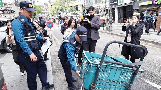 경찰 기동순찰대원이 지난해 4월 서울 종로구 일대 순찰 중 길가에 세워진 오토바이에 대해 불법 주·정차 단속을 하는 모습. 연합뉴스