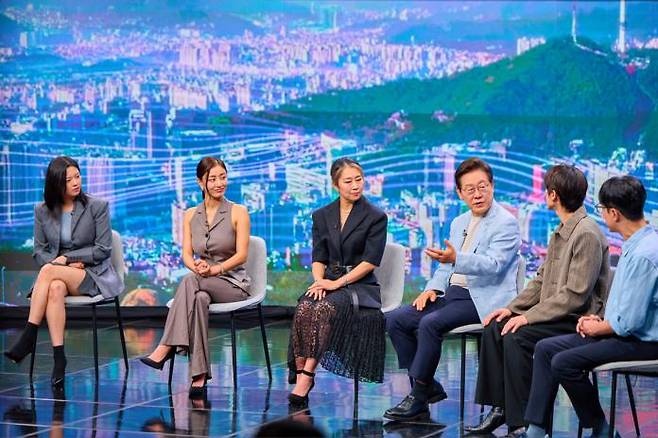 President Lee Jae-myung (third from right) speaks with Maggie Kang (third from left), director of “K-Pop Demon Hunters,” and others during a TV show recording at the Arirang TV studios in Seoul on August 20. / Courtesy of the presidential office