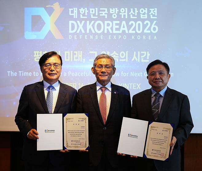 ◇ 21일 서울 삼성동 코엑스에서 DX KOREA 2026 조직위원회가 한국방위산업MICE협회 김영후 이사장(가운데)이 권평오 전 코트라 사장(왼쪽)과 박한기 전 합참의장 (육군대장)에게 공동 조직위원장으로 위촉장을 전달하고 있다.