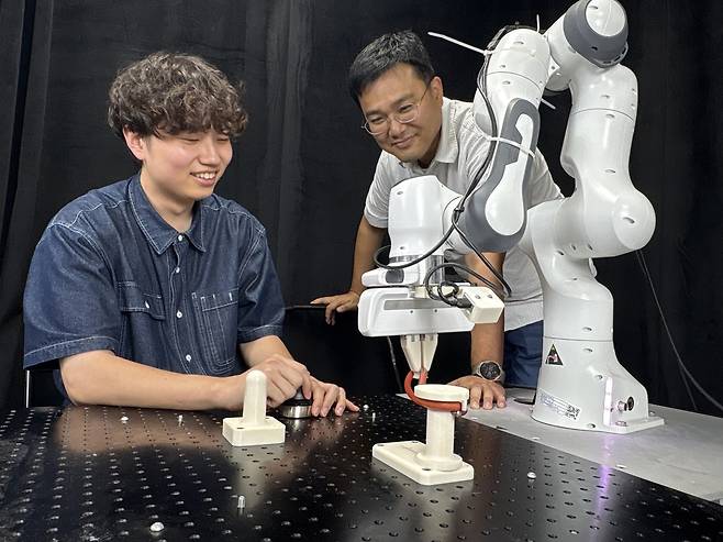 박대형(오른쪽) KAIST 교수와 (왼쪽부터) 송민석 석사과정이 이 기술이 적용된 로봇팔을 점검하고 있다.[KAIST 제공]