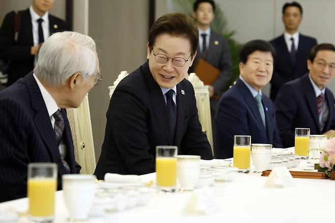 이재명 대통령이 21일 용산 대통령실에서 열린 더불어민주당 상임고문단과 오찬 간담회에서 임채정 전 국회의장과 인사하고 있다. [연합]