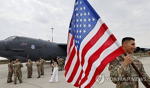 루마니아 미하일 코걸니차누 공군기지의 미국 군인 (EPA=연합뉴스) 2025년 7월 23일 흑해 연안 루마니아 미하일 코걸치나추 공군기지에서 열린 언론 행사에서 한 미국 군인이 B52 폭격기를 배경으로 성조기를 들고 걸어가고 있다. (EPA/ROBERT GHEMENT) 2025.8.21.