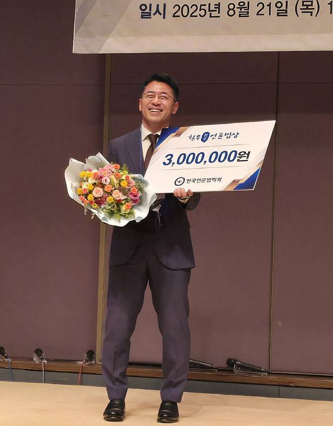 양재규 변호사가  철우언론법상을 수상하고 상금 300만원과 꽃다발을 받고 기뻐하고 있다.