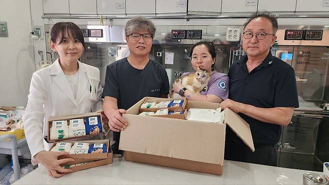 로얄동물메디컬센터 정인성 대표원장(오른쪽 첫 번째), 김가연 원장(왼쪽 첫 번째), 유용규 원장(왼쪽 두 번째) 등 의료진이 산불 현장 구조묘와 함께 선물 받은 제품들과 기념 사진을 찍고 있다(병원 제공). ⓒ 스1