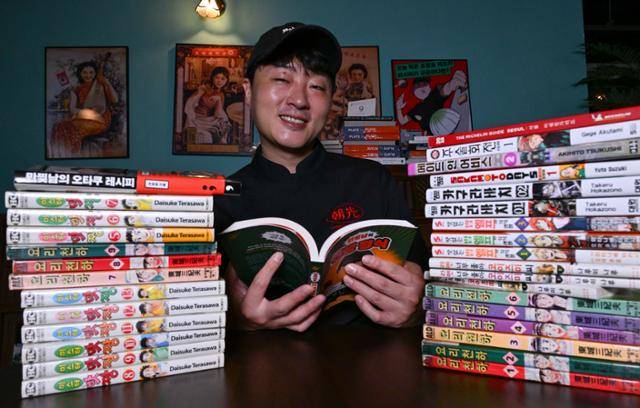'만화책 찢어서 요리하는 남자(만찢남)'로 유명한 조광효 셰프가 자신의 식당 '조광201'에서 요리에 영감을 준 만화책 사이에 앉아 미소 짓고 있다. 강예진 기자