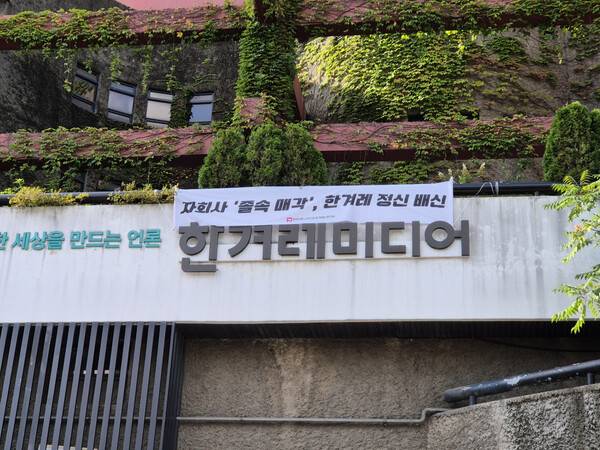 ▲22일 언론노조 한겨레지부가 한겨레 사옥 간판에 부착한 '허프 졸속 매각 규탄' 플래카드. 언론노조 한겨레지부 제공