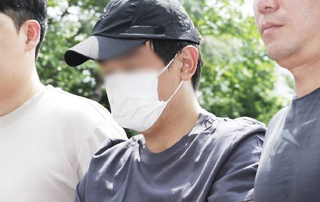 경기 용인시 오피스텔 지하 주차장에서 중국 국적 30대 여성을 살해한 뒤 달아난 살인 용의자 A씨가 22일 경기도 용인서부경찰서로 압송되고 있다. (사진=연합뉴스)