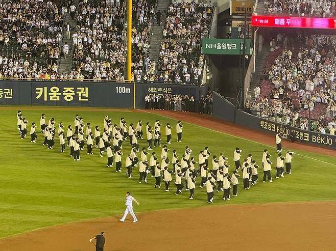 지난 6일 잠실구장에서 열린 두산 베어스와 LG 트윈스의 경기에서 클리닝 타임 공연을 가지는 보이즈 2 플래닛 출연자들을 '대포 카메라'를 든 관객들이 감싸고 있다.