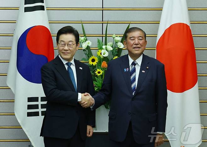 이재명 대통령과 이시바 시게루 일본 총리가 23일 일본 도쿄 총리 관저에서 열린 한일 확대정상회담에 앞서 악수하고 있다. ⓒ AFP=뉴스1