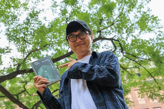 소설가 이기호가 그의 신작 장편 소설을 들어 보였다. /박성원 기자