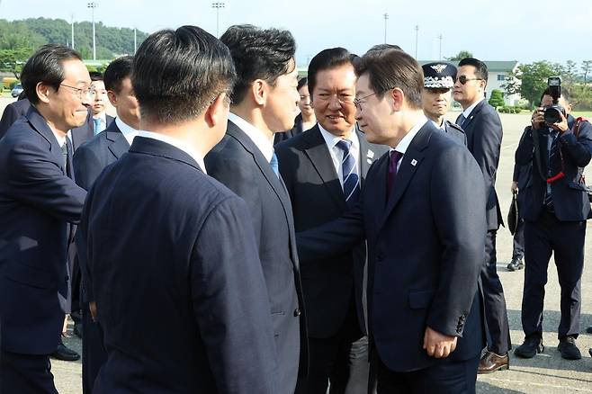 이재명 대통령이 한일 정상회담을 위해 23일 경기 성남 서울공항에 도착해 공군 1호기에 탑승 전 정청래 더불어민주당 대표, 우상호 정무수석 등과 인사하고 있다. 2025.08.23.  [성남=뉴시스]