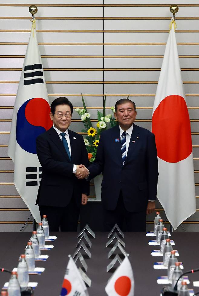 이재명 대통령과 이시바 시게루 일본 총리가 23일 일본 도쿄 총리 관저에서 열린 한일 확대정상회담에 앞서 기념촬영을 하며 악수하고 있다. [연합]