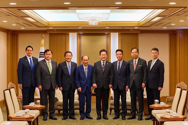 이재명 대통령이 24일 일본 도쿄의 한 호텔에서 일한의원연맹 회장인 스가 요시히데 전 일본 총리 등 일본 의원단을 접견하며 기념촬영을 하고 있다. /연합뉴스