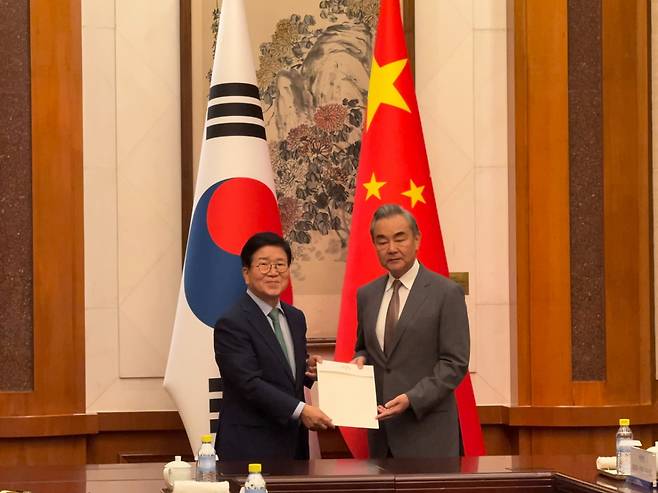 이재명 대통령 특사단 단장인 박병석 전 국회의장(사진 왼쪽)이 왕이 중국공산당 중앙외사판공실 주임 겸 외교부장을 24일 중국 베이징 댜오위타이에서 만나 이 대통령의 친서를 전달하고 있다./사진=베이징특파원 공동취재단
