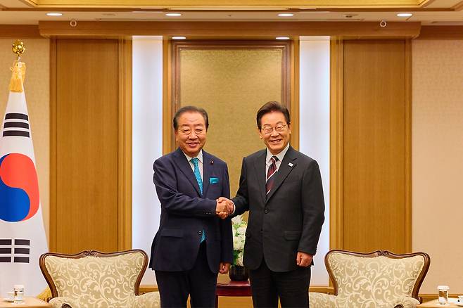 이재명 대통령이 24일 일본 도쿄의 한 호텔에서 노다 요시히코 입헌민주당 대표와 인사하고 있다. [연합]