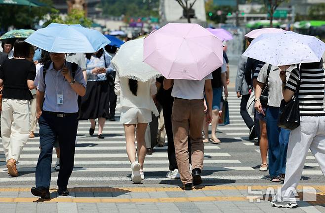 [서울=뉴시스] 이영환 기자 = 더위가 그친다는 절기상 처서를 하루 앞두고 찜통 더위가 이어지고 있는 22일 서울 종로구 광화문 네거리에서 양산을 쓴 시민들이 걸어가고 있다. 2025.08.22. 20hwan@newsis.com