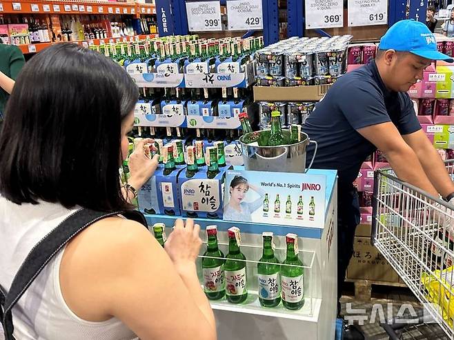 [마닐라=뉴시스] 필리핀 수도 마닐라에 위치한 코스트코(Costco) 스타일의 회원제 창고형 할인 매장인 S&R에서 필리핀 소비자가 하이트진로 시음 행사장을 찾아 진로 제품을 구매하고 있다. (사진= 하이트진로 제공) photo@newsis.com