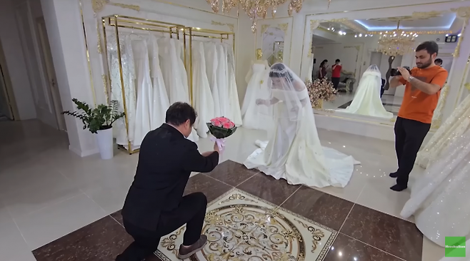 국제결혼을 위해 우즈베키스탄에 간 한국인 남성이 웨딩드레스를 입은 현지인 신부에게 꽃다발을 주는 장면을 연출하며 웨딩 촬영에 임하고 있다. 유튜브 채널 ‘희철리즘’ 캡처