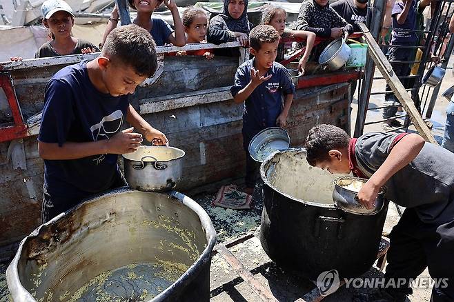 가자지구 기근 발생 텅빈 원조 냄비 바닥을 긁고있는 팔레스타인 소년들 [AFP 연합뉴스. 재판매 및 DB 금지]
