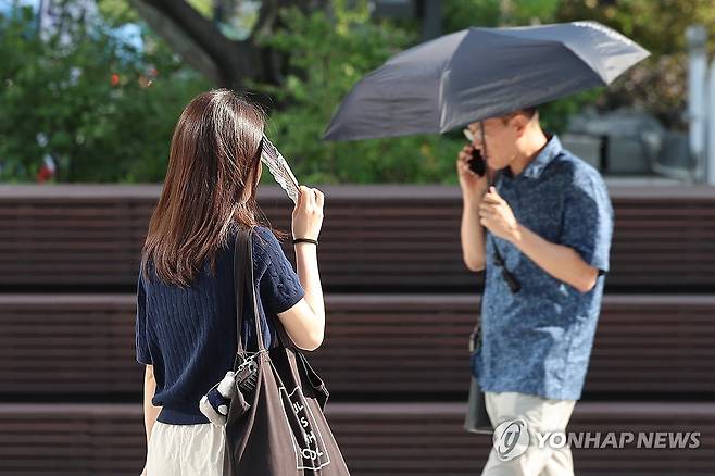 너무 뜨거운 햇빛 (서울=연합뉴스) 서대연 기자 = 서울 한낮 기온이 33도까지 오르며 더운 날씨를 보인 21일 서울 종로구 광화문광장에서 시민들이 양산을 쓰거나 부채로 햇빛을 가리고 있다. 2025.8.21 dwise@yna.co.kr