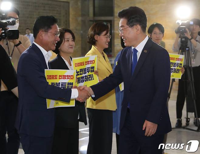이재명 대통령이 더불어민주당 대표 시절이던 2023년, 서울 여의도 국회 로텐더홀에서 노란봉투법 처리 촉구 피케팅을 하고 있는 정의당 의원들과 인사하고 있다. 2023.6.19/뉴스1 ⓒ News1 송원영 기자