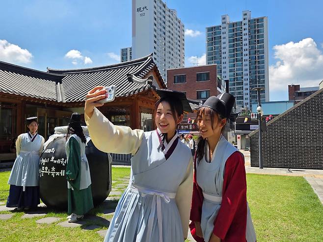 Japanese tourist Matsuno Sora poses for a photo with family members in traditional medical attire at the Seoul K-Medi Center in Dongdaemun District, Seoul, on Aug. 10./Jang Yoon