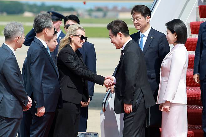 이재명 대통령이 24일 미국 워싱턴 DC 인근 앤드루스 공군기지에 도착해 에비게일 존스 국무부 부의전장과 악수를 하고 있다. /연합뉴스