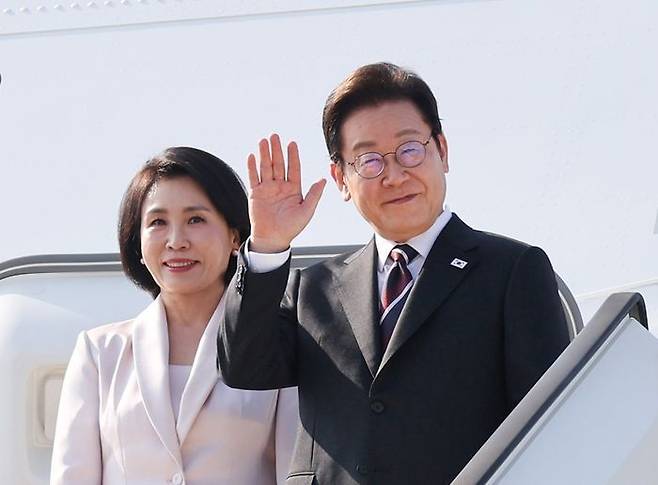 한일정상회담을 마친 이재명 대통령과 배우자 김혜경 여사가 24일 일본 도쿄 하네다 국제공항에서 도널드 트럼프 미국 대통령과의 한미정상회담을 위해 워싱턴DC로 향하며 공군 1호기에 올라 인사하고 있다. ⓒ연합뉴스