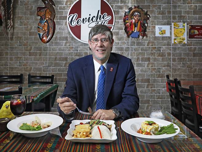 Paul Duclos, Peru’s ambassador to Korea, poses with traditional Peruvian dishes during an interview with the Korea JoongAng Daily at Ceviche 210 in Pyeongtaek, Gyeonggi, on July 17. [PARK SANG-MOON]