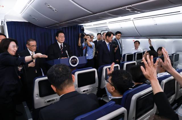 50분간… “질문 받습니다”  : 이재명 대통령이 24일 일본에서 미국 워싱턴DC로 향하는 공군 1호기 기내에서 기자간담회를 열고 취재진의 질문을 받고 있다.  연합뉴스