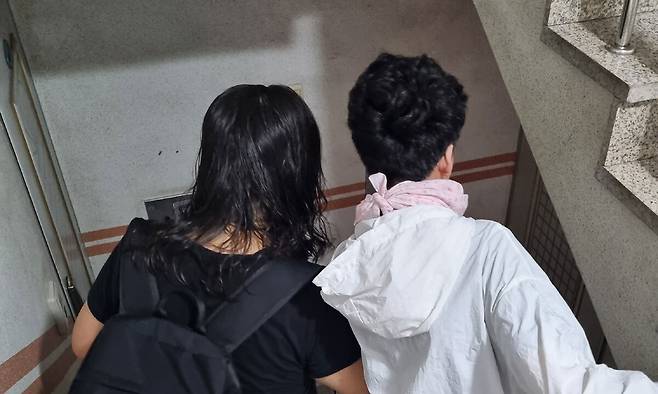 중증장애 학생 이명성군의 어머니 최춘미씨가 20일 오전 7시40분 서울 관악구 신림동의 자택에서 이군을 부축하면서 계단을 내려 오고 있다.